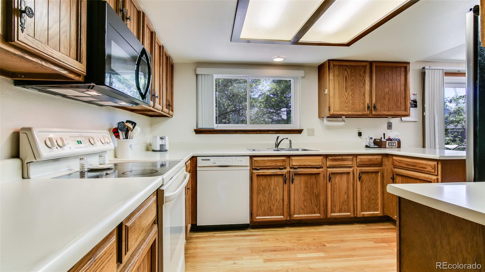 82 Prairie Ridge Road Highlands Ranch, CO 80126 - Photo 11 of 29 a kitchen with stainless steel appliances granite countertop a sink dishwasher stove and cabinets with wooden floor