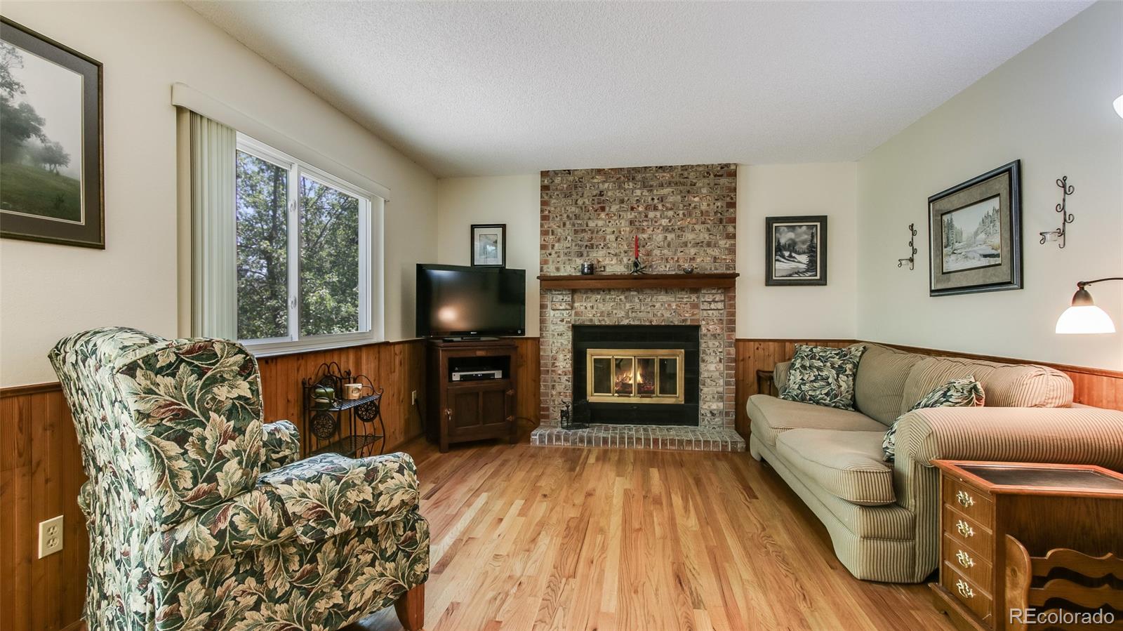 82 Prairie Ridge Road Highlands Ranch, CO 80126 - Photo 8 of 29 a living room with furniture a flat screen tv and a fireplace