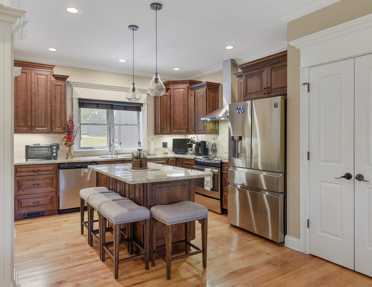 2793 Thompson Road Murfreesboro, TN 37128 - Photo 15 of 62 a kitchen with stainless steel appliances a refrigerator a stove a sink and white cabinets with wooden floor