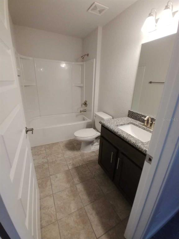 4380 Southwest 92nd Pl Road Ocala, FL 34476 - Photo 39 of 57 a bathroom with a granite countertop sink a toilet and bathtub
