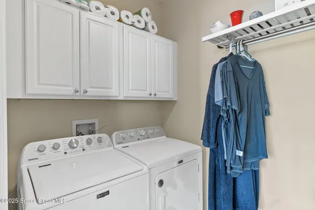 a kitchen with granite countertop white cabinets white appliances and a window