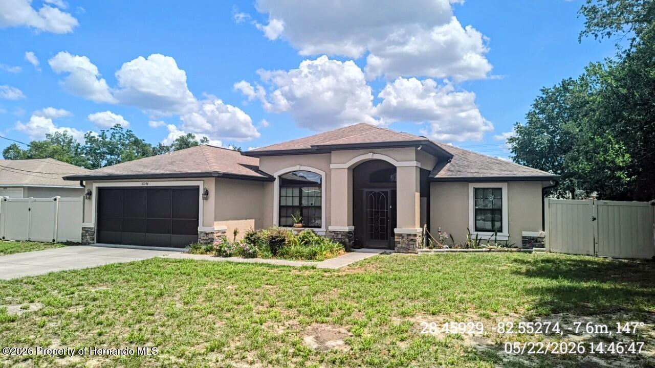 10244 Heathcliff Street Spring Hill, FL 34608 - Photo 2 of 30 a front view of a house with garden