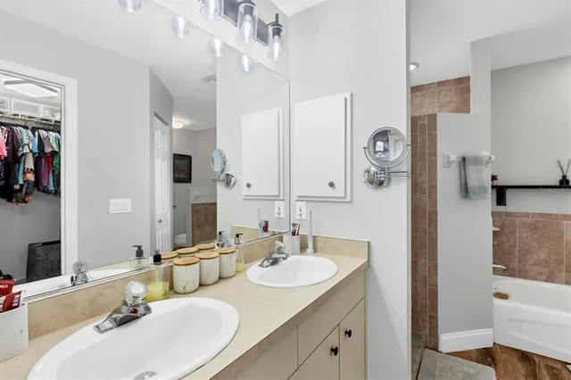 a bathroom with a sink double vanity granite tub shower and a mirror