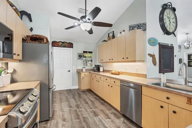 a very nice looking open kitchen with a stove a sink and a refrigerator