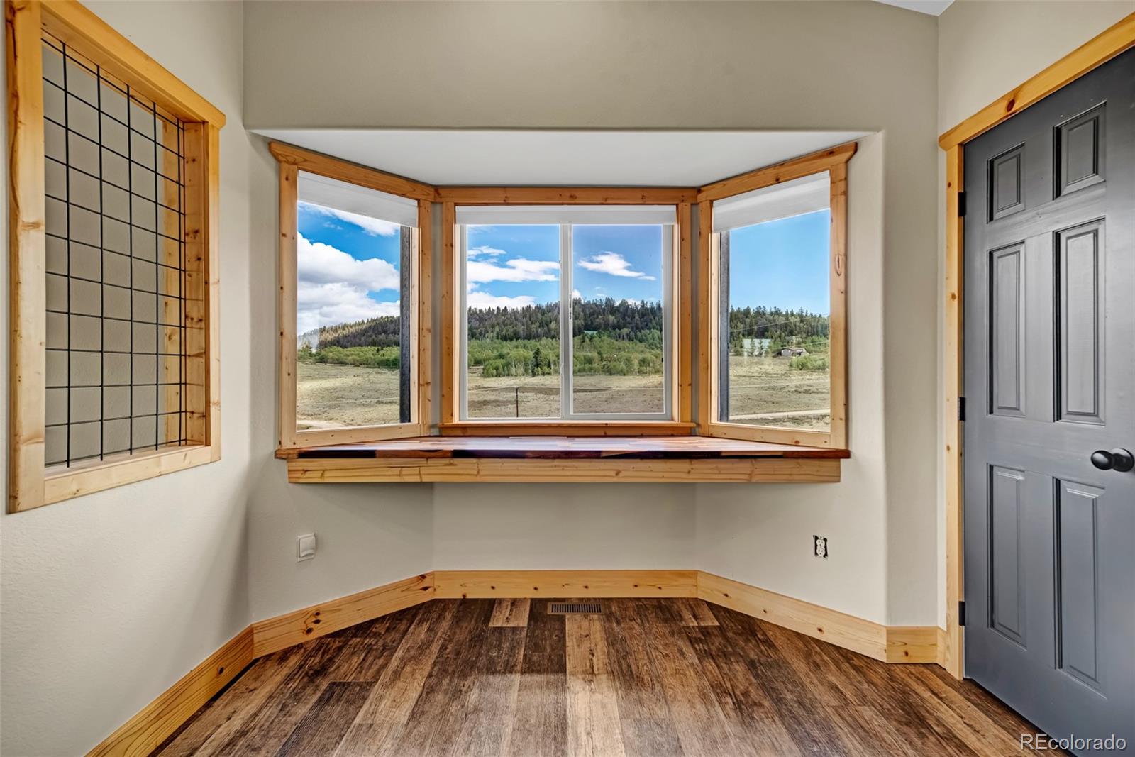 2491 Stagestop Road Jefferson, CO 80456 - Photo 11 of 46 a view of a bedroom with a window and wooden floor