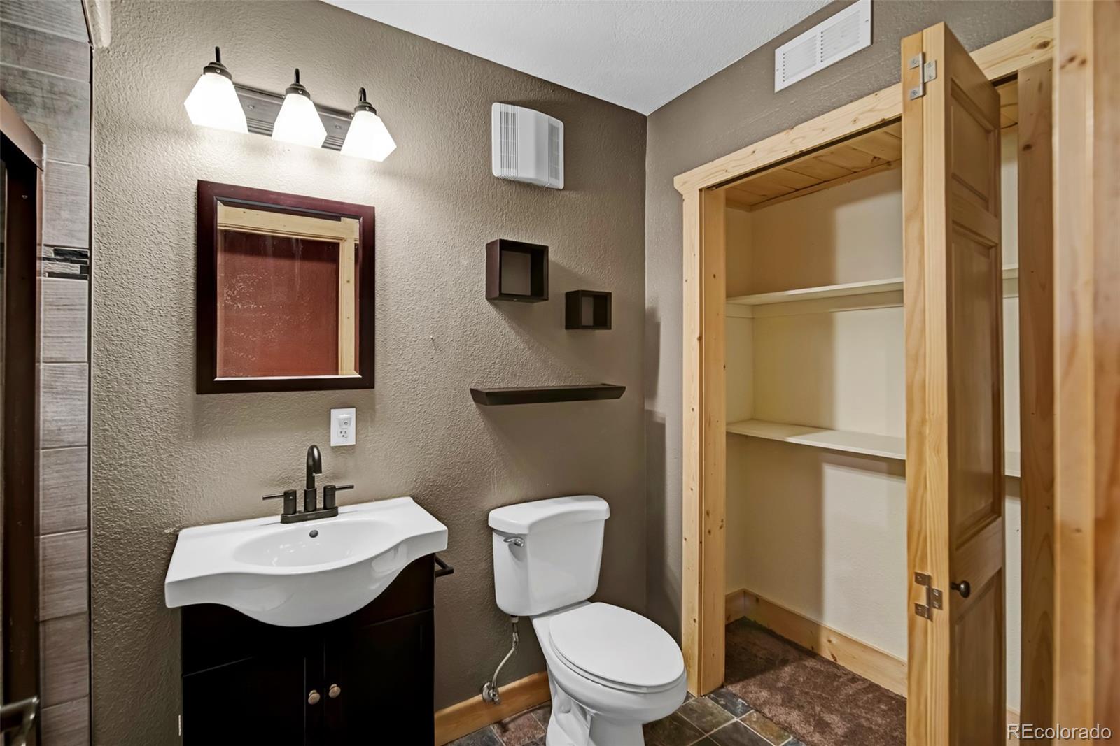 2491 Stagestop Road Jefferson, CO 80456 - Photo 24 of 46 a bathroom with a toilet a sink and mirror