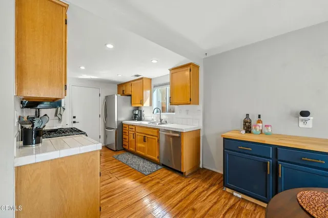 a kitchen with a sink wooden floor and stove top oven