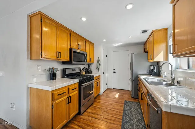 a kitchen with stainless steel appliances granite countertop a stove a sink and a microwave