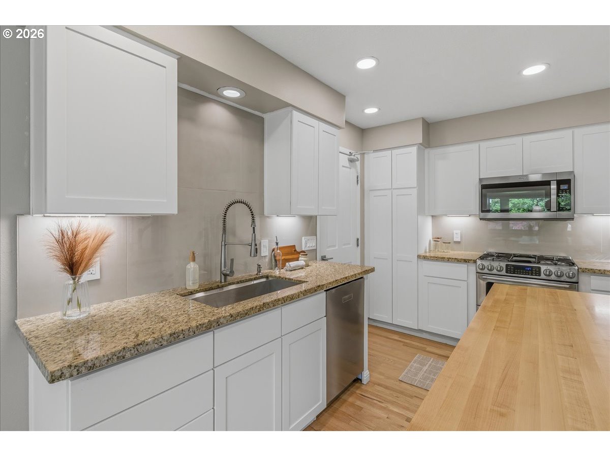 3130 Southwest 116th Avenue Beaverton, OR 97005 - Photo 13 of 44 a kitchen with stainless steel appliances granite countertop a sink stove and cabinets