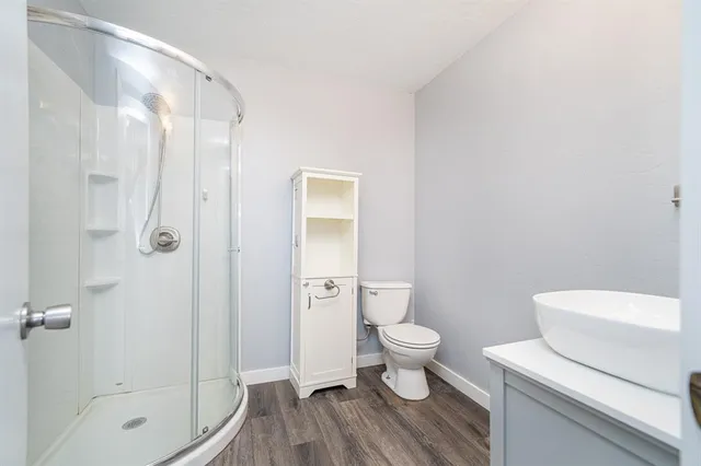 a bathroom with a granite countertop toilet a sink and a shower