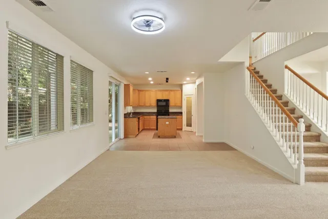 a view of a livingroom with furniture stairs and a large window