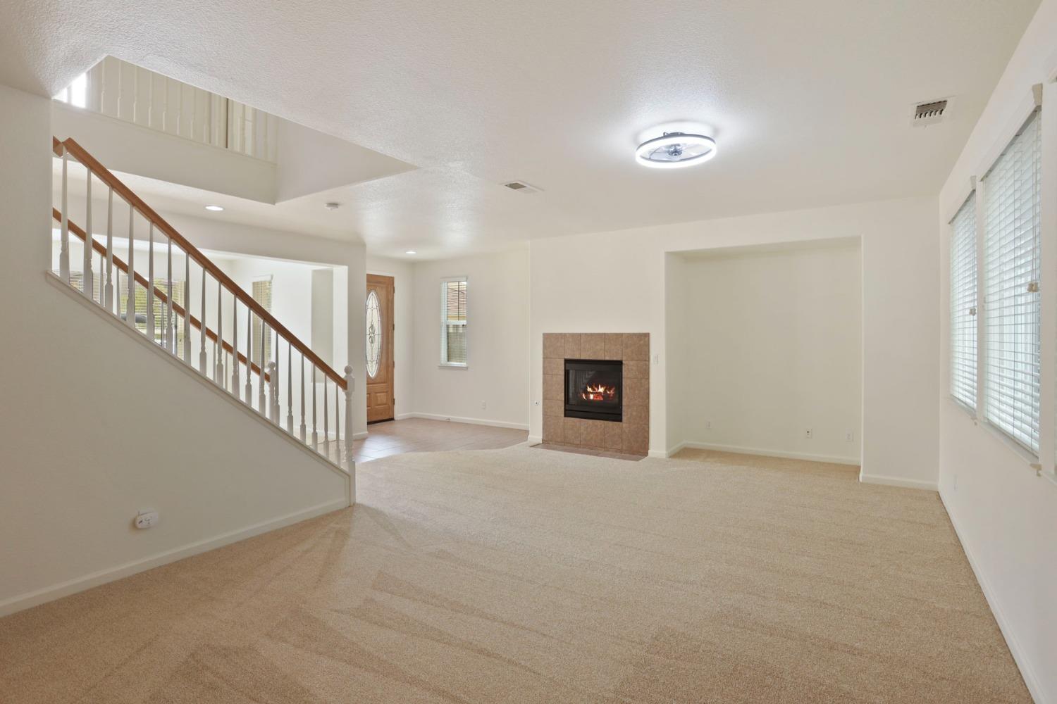 9363 Vintner Circle Patterson, CA 95363 - Photo 13 of 52 a view of an empty room with fireplace and a window