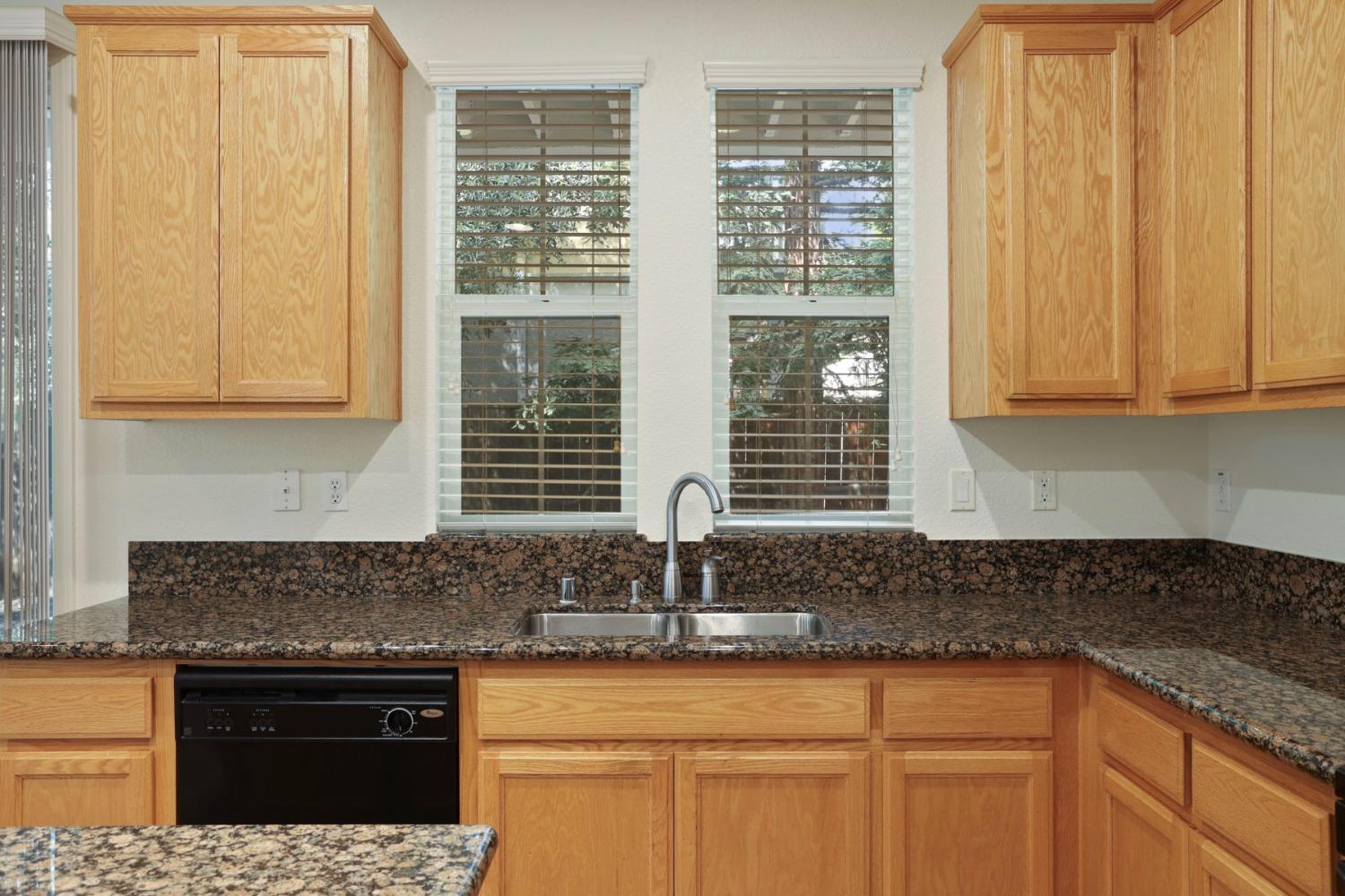 9363 Vintner Circle Patterson, CA 95363 - Photo 16 of 52 a kitchen with stainless steel appliances granite countertop a sink and a granite counter tops