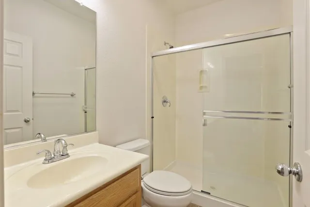 a bathroom with a sink mirror toilet and shower