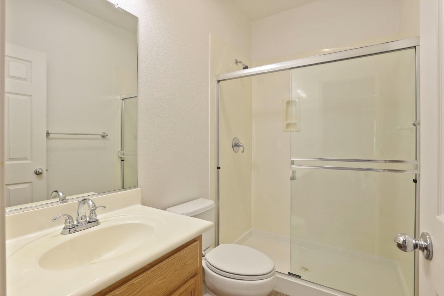 9363 Vintner Circle Patterson, CA 95363 - Photo 20 of 52 a bathroom with a sink mirror toilet and shower