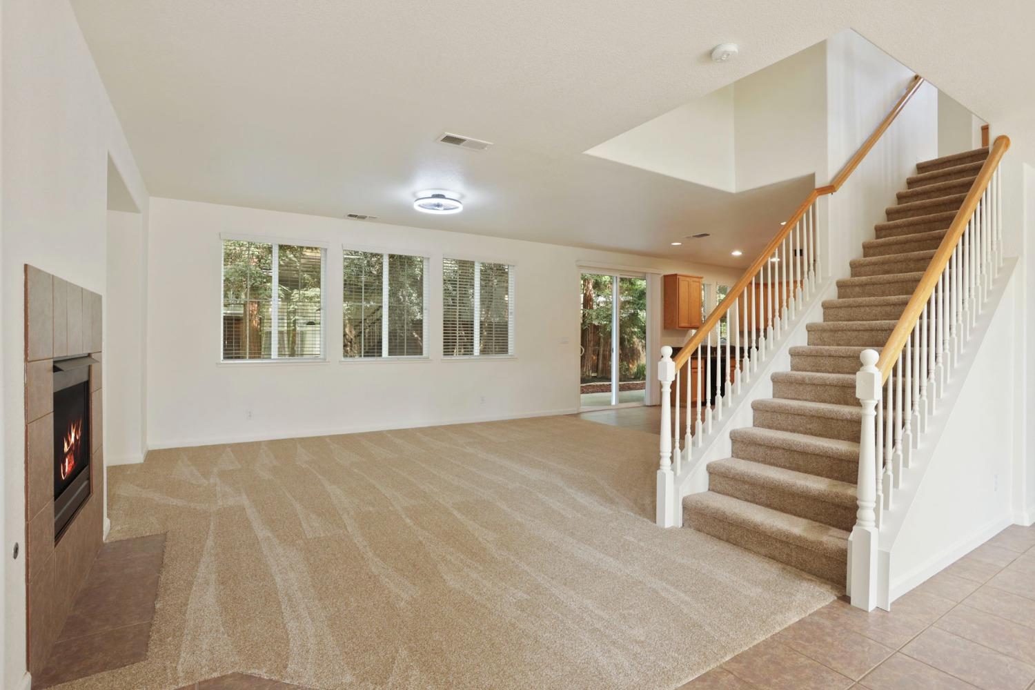 9363 Vintner Circle Patterson, CA 95363 - Photo 4 of 52 a view of an empty room with wooden floor and a fireplace
