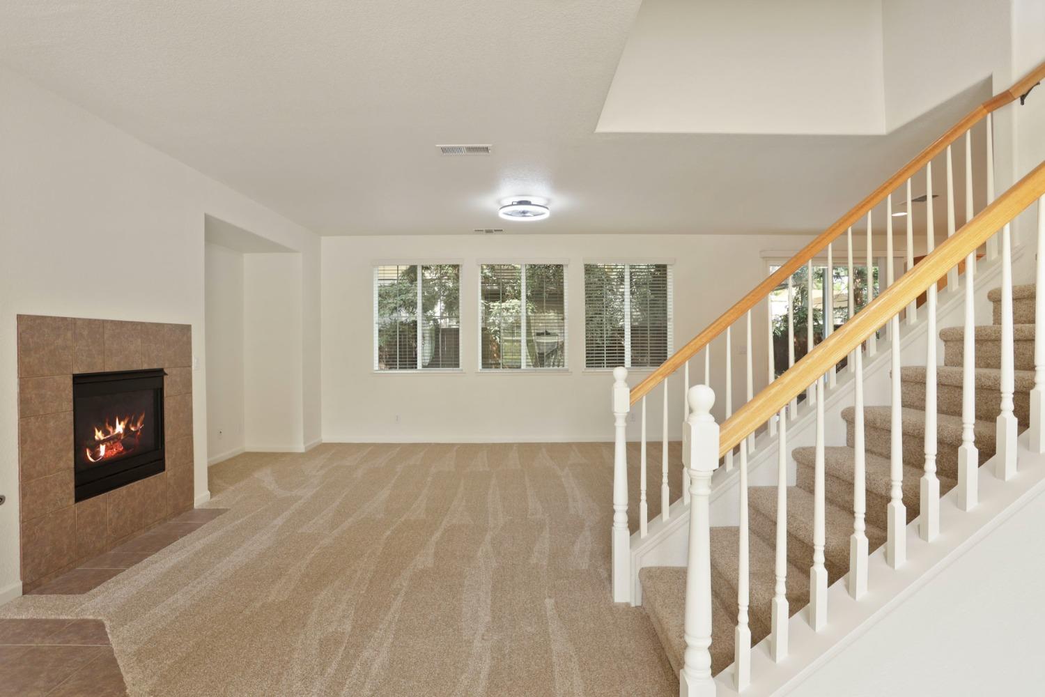 9363 Vintner Circle Patterson, CA 95363 - Photo 7 of 52 a view of an empty room with wooden floor fireplace and a window