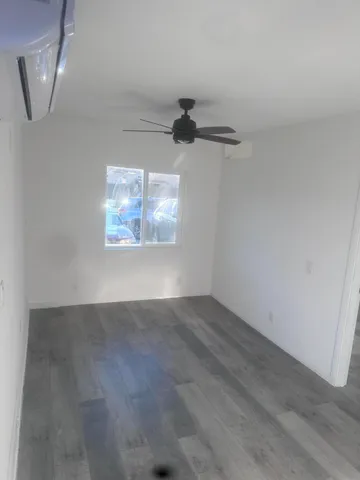 an empty room with windows and ceiling fan
