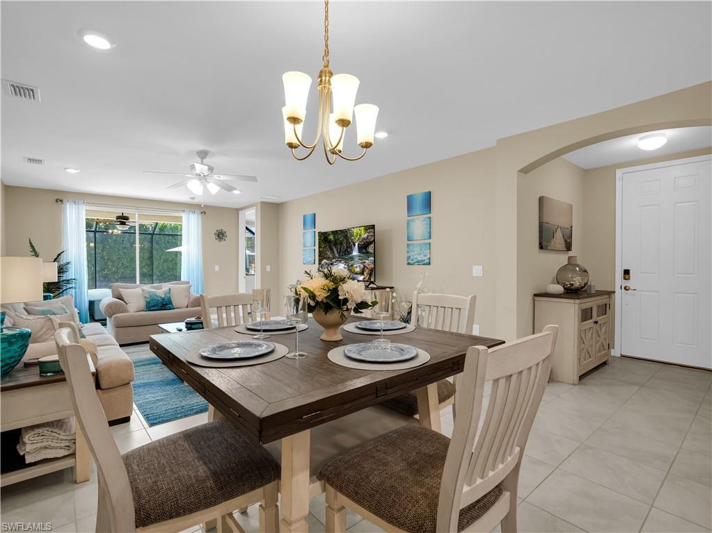 14695 Edgewater Circle Naples, FL 34114 - Photo 5 of 39 a view of a dining room with furniture wooden floor and chandelier