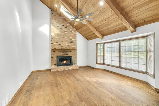 a view of an empty room with a fireplace and a window