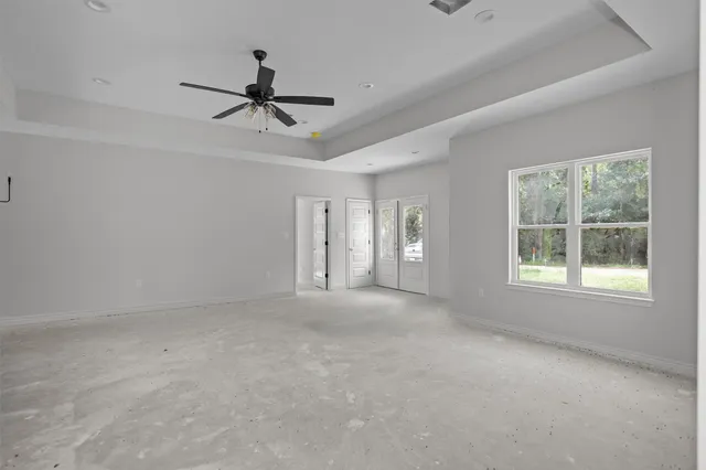 an empty room with a window and a ceiling fan