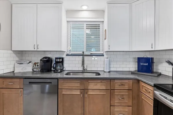 a kitchen with granite countertop a sink and cabinets
