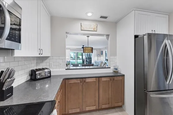 a kitchen with granite countertop a refrigerator a stove a sink and dishwasher