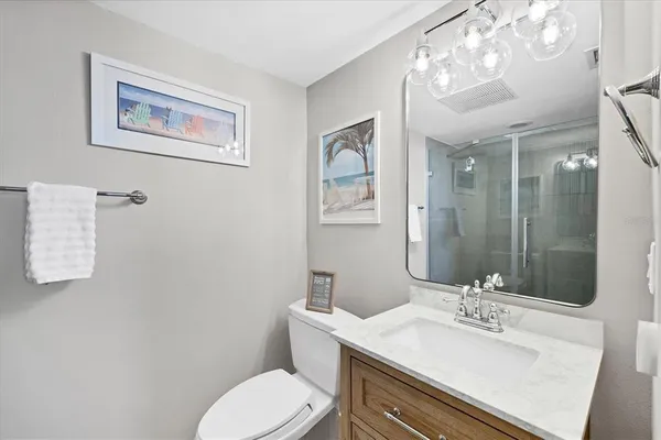 a bathroom with a sink vanity mirror and toilet