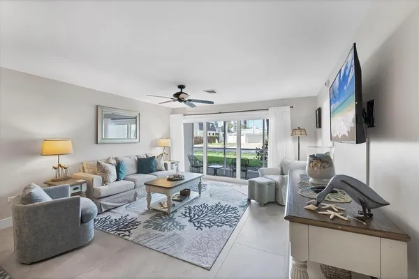 a living room with furniture a flat screen tv and a window