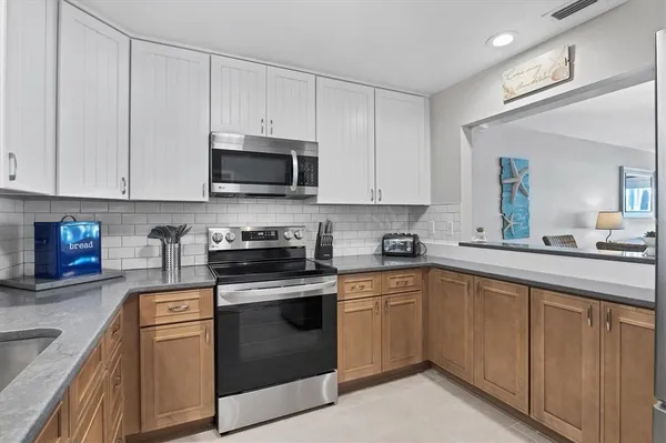 a kitchen with cabinets stainless steel appliances and a sink