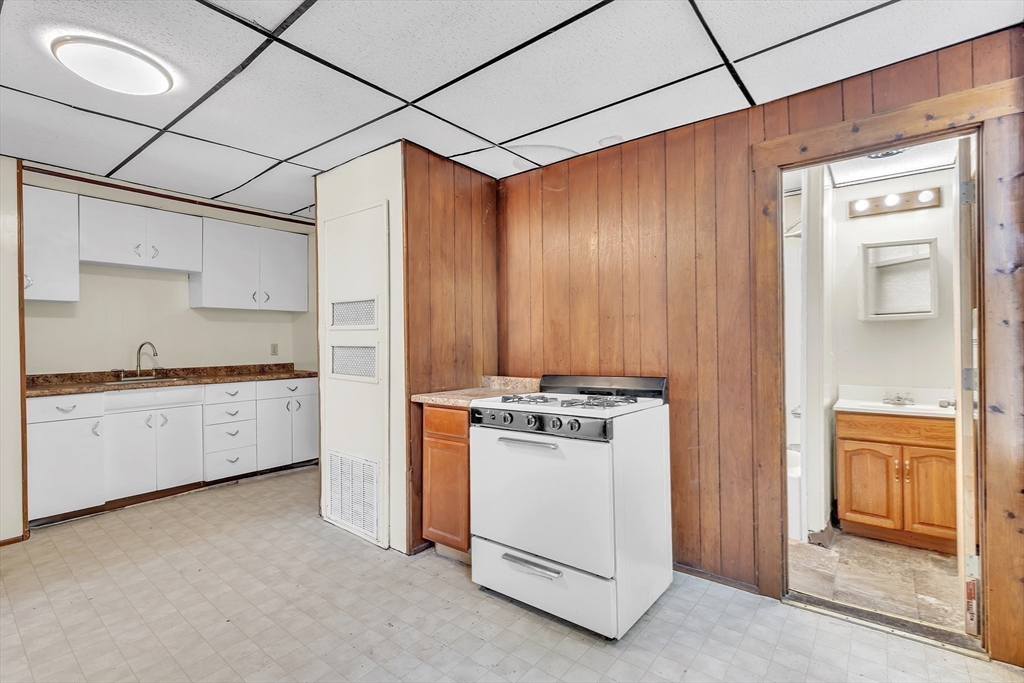 256 Whipple Street Fall River, MA 02721 - Photo 33 of 42 a kitchen with a stove and white cabinets