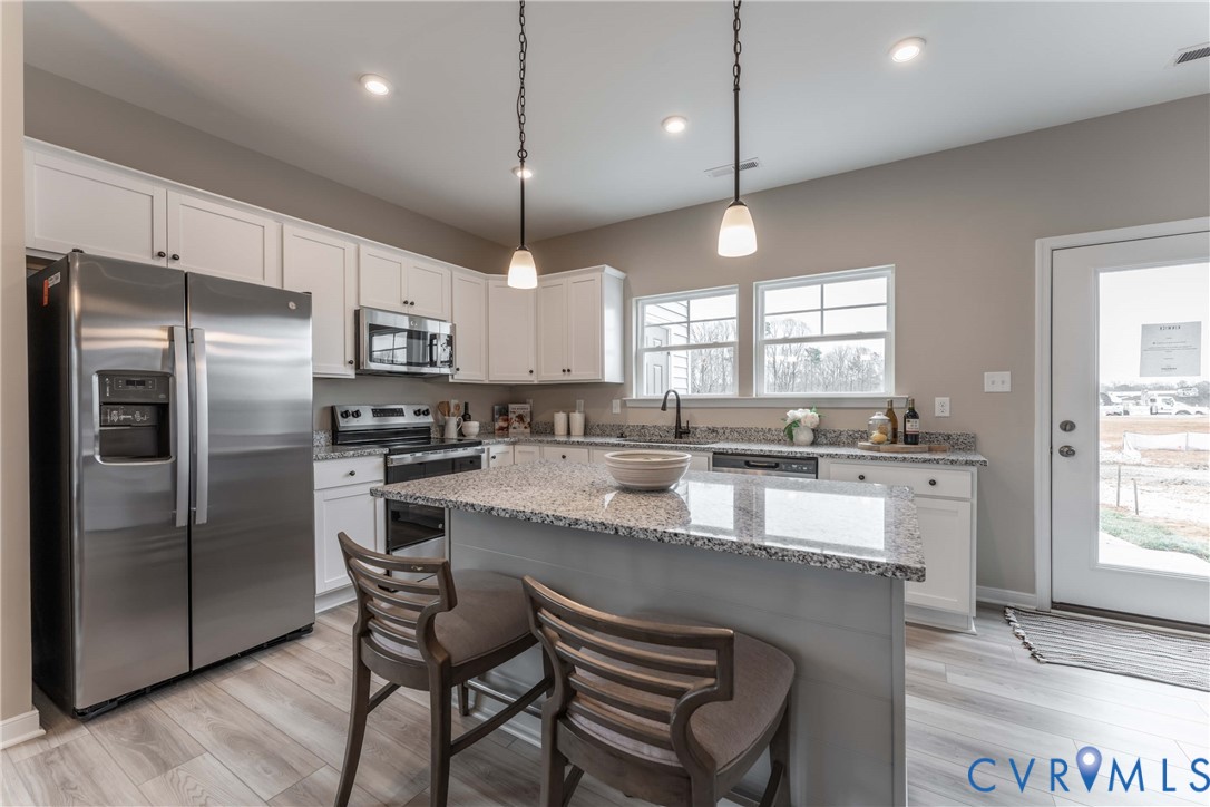 3457 Broadwick Road Richmond, VA 23234 - Photo 8 of 24 a large kitchen with a center island wooden floor stainless steel appliances and windows