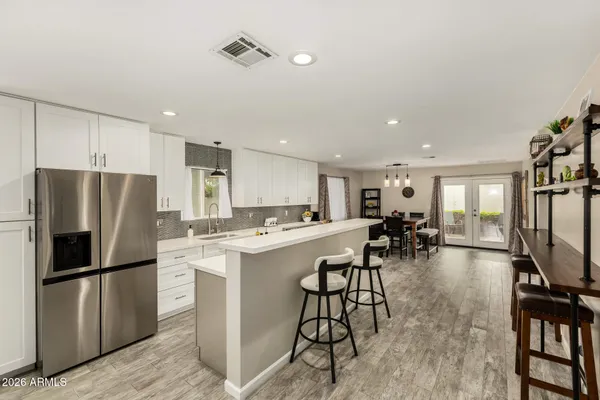 a kitchen with appliances a refrigerator and a dining table