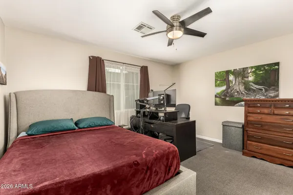 a bedroom with a bed and dresser with mirror