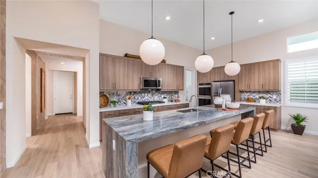 a kitchen with granite countertop a stove a sink a dining table and chairs