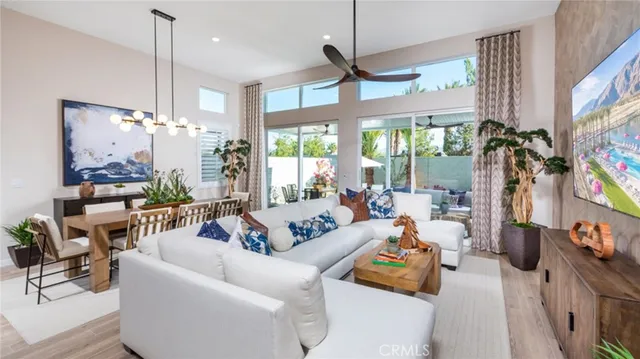 a living room with furniture a chandelier and a flat screen tv
