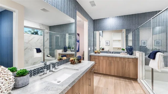 a bathroom with a granite countertop sink a mirror and a shower