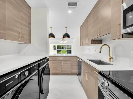 a kitchen with stainless steel appliances a stove sink microwave and cabinets