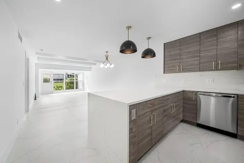 a kitchen with kitchen island stainless steel appliances a sink and cabinets