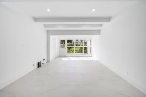 an empty room with windows and ceiling fan