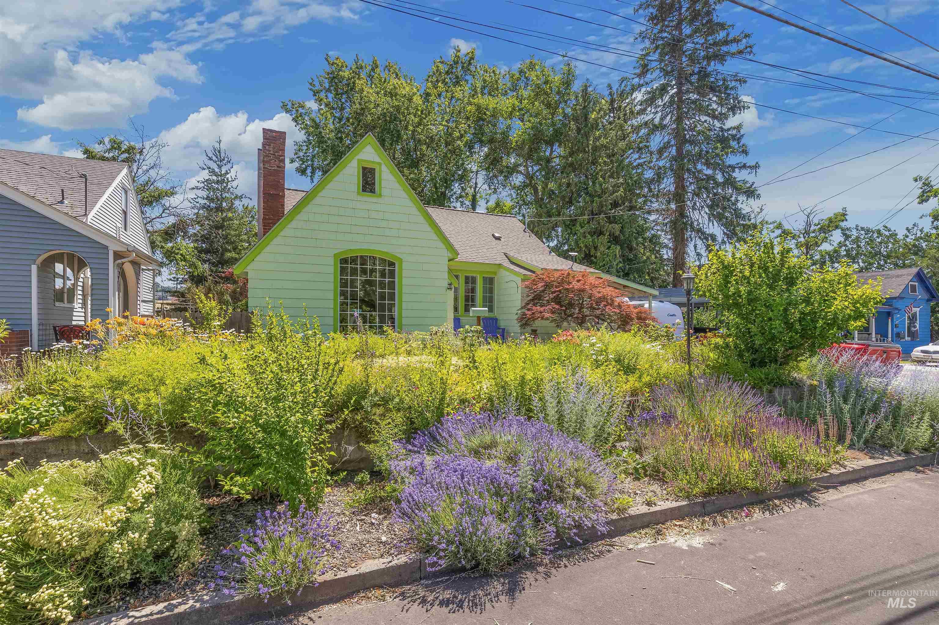 924 N Street Lewiston, ID 83501 - Photo 1 of 46 Light green shingle siding with bright green trim, arched window, and prominent brick chimney