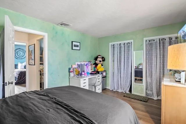 a bedroom with a bed and a flat tv screen on dresser
