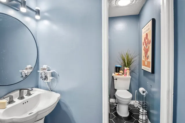 a bathroom with a sink a toilet and a mirror