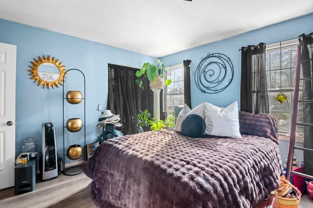 a bedroom with a bed and painting on the wall