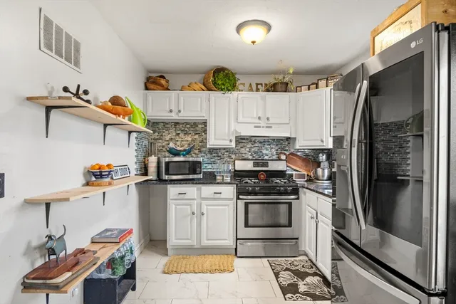 a kitchen with stainless steel appliances granite countertop a refrigerator and a stove