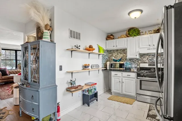 a kitchen with a refrigerator and a stove top oven