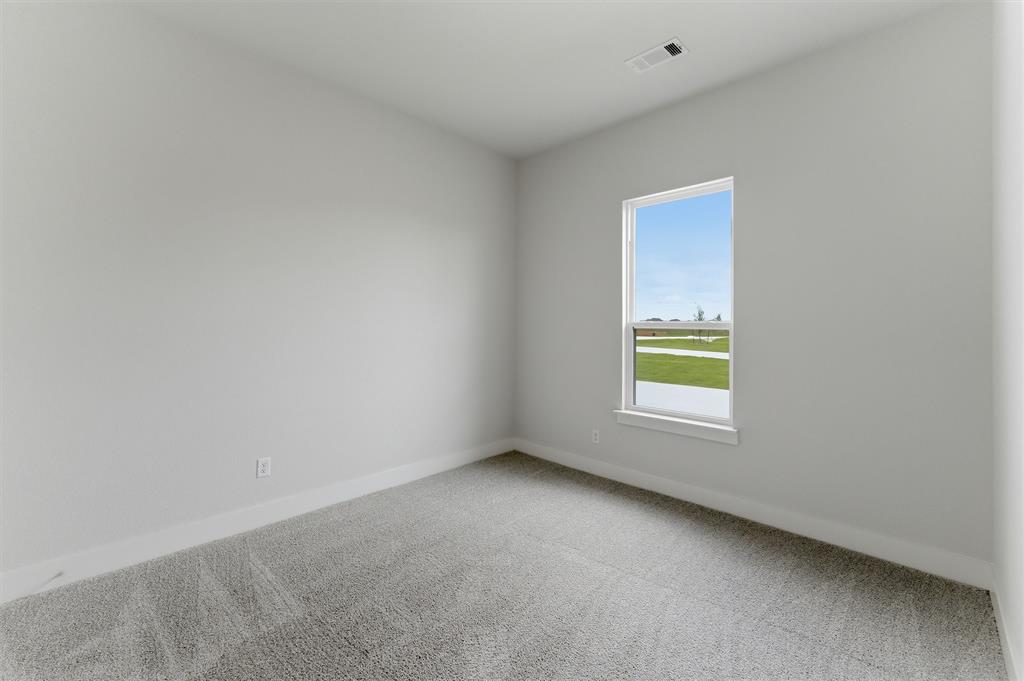 2204 Continent Court Krum, TX 76249 - Photo 21 of 28 Room with light gray walls, gray carpet, white baseboards, and a single window with white trim, featuring an exterior view of a green landscape under a blue sky