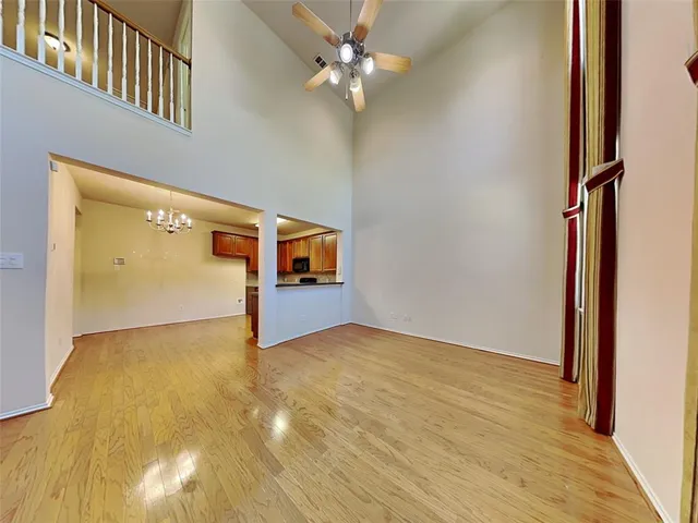 a view of a big room with wooden floor and a ceiling fan