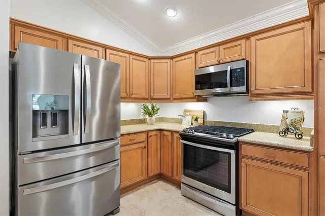 a kitchen with stainless steel appliances granite countertop a refrigerator stove top oven a sink and dishwasher