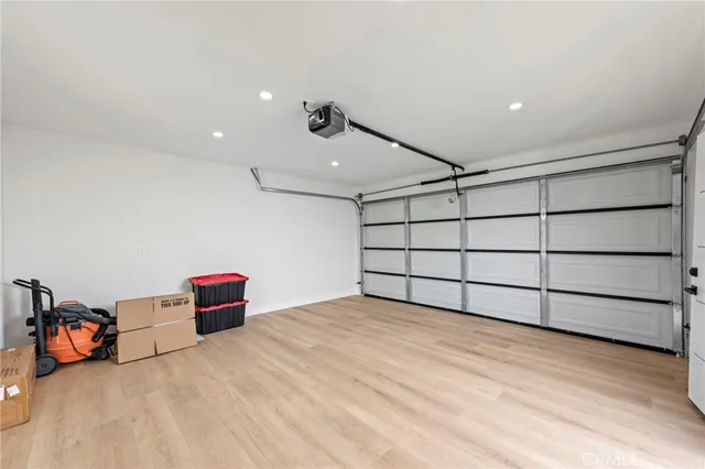 a view of a white house next to a yard with big trees